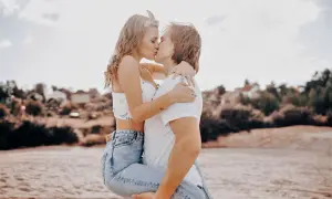 Ein Mann hält eine Frau im Arm, sie küssen sich leidenschaftlich. Ihre Liebe ist eine Entscheidung, die sie jeden Tag aufs Neue treffen.