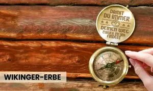 Ein antiker Kompass auf Holz, der dazu ermutigt, dem Leben zu vertrauen und immer den Weg zurückzufinden. "Wikinger-Erbe" steht darunter.