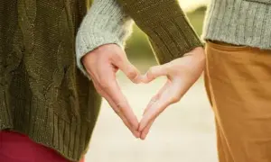 Zwei Hände formen ein Herz, ein Symbol für eine tiefe Partnerbeziehung.