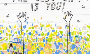 Bunte Wandmalerei mit der Botschaft "The best gift is you!". Eine Frau schiebt einen Kinderwagen. Dies erinnert an die psychologischen werte tests, die uns lehren, uns selbst wertzuschätzen.
