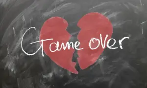 Ein zerbrochenes Herz auf einer Tafel mit der Aufschrift "Game Over". Ein Symbol für den tiefen Schmerz und die Trauer nach einer Trennung.