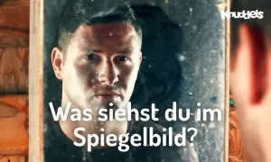 Ein Mann blickt in einen Spiegel und fragt sich, was er sieht. Ist es der Weg zum Erfolg im Leben?