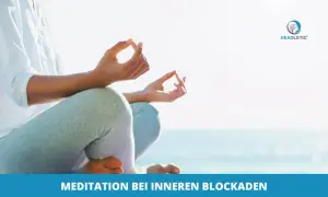 Person meditiert am Strand, um innere Blockaden zu lösen. Hände in Mudra-Geste, Fokus auf Entspannung und Klarheit.