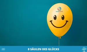 Ein gelber Smiley-Ballon schwebt vor blauem Hintergrund. Er symbolisiert das Ende der Unzufriedenheit im Leben und die Suche nach Glück.
