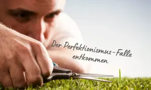 Mann schneidet mit Schere ein einzelnes Grashalm. Die Psychologie des Perfektionismus zeigt sich in diesem Detail.
