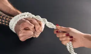 Zwei Hände ziehen an einem Seil. Eine Hand ist gefesselt, ein Test, ob man keine Liebe empfinden kann.