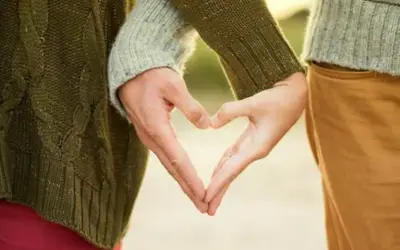 Zwei Hände formen ein Herz, ein Symbol für eine tiefe Partnerbeziehung.