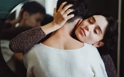 Frau umarmt ihren Partner, der sich abwendet. Sie sucht Nähe, wenn sie sich depressiv fühlt. Was tun?