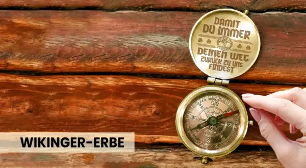 Ein antiker Kompass auf Holz, der dazu ermutigt, dem Leben zu vertrauen und immer den Weg zurückzufinden. "Wikinger-Erbe" steht darunter.