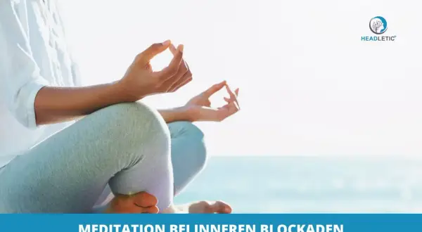 Person meditiert am Strand, um innere Blockaden zu lösen. Hände in Mudra-Geste, Fokus auf Entspannung und Klarheit.