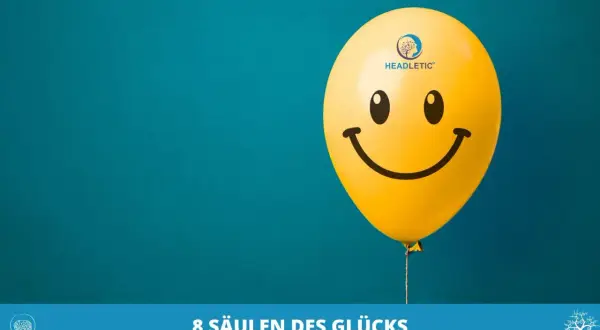 Ein gelber Smiley-Ballon schwebt vor blauem Hintergrund. Er symbolisiert das Ende der Unzufriedenheit im Leben und die Suche nach Glück.