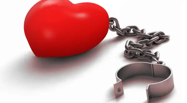 Ein rotes Herz, gefesselt an eine Kette mit einem offenen Bügel. Es symbolisiert die Angst, die Liebe zu verlieren, oder die Last einer unerwiderten Liebe.