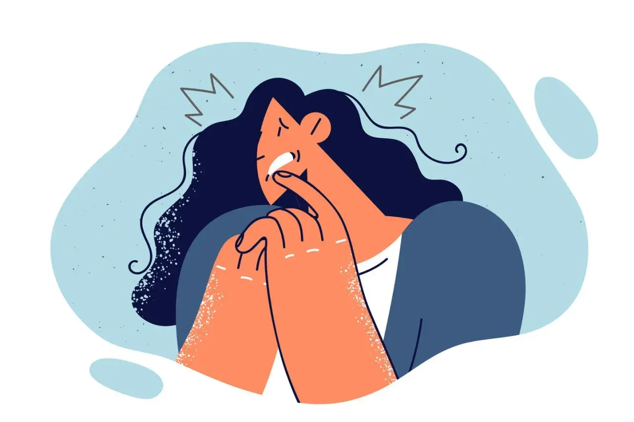 Verzweifelte Frau mit dunklen Haaren, die sich die Finger in den Mund steckt. Ein Symbol für Schuldzuweisung in der Psychologie, das innere Qualen darstellt.