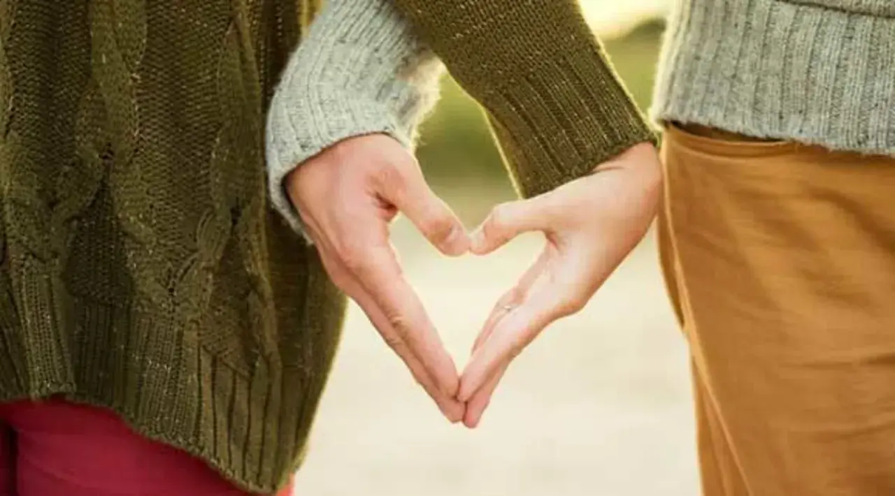 Zwei Hände formen ein Herz, ein Symbol für eine tiefe Partnerbeziehung.