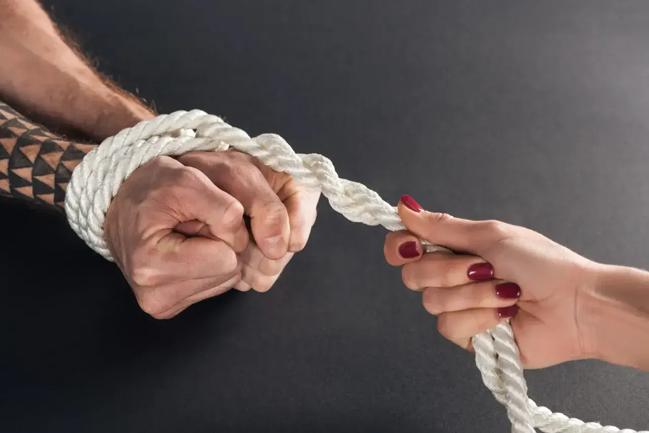 Zwei Hände ziehen an einem Seil. Eine Hand ist gefesselt, ein Test, ob man keine Liebe empfinden kann.