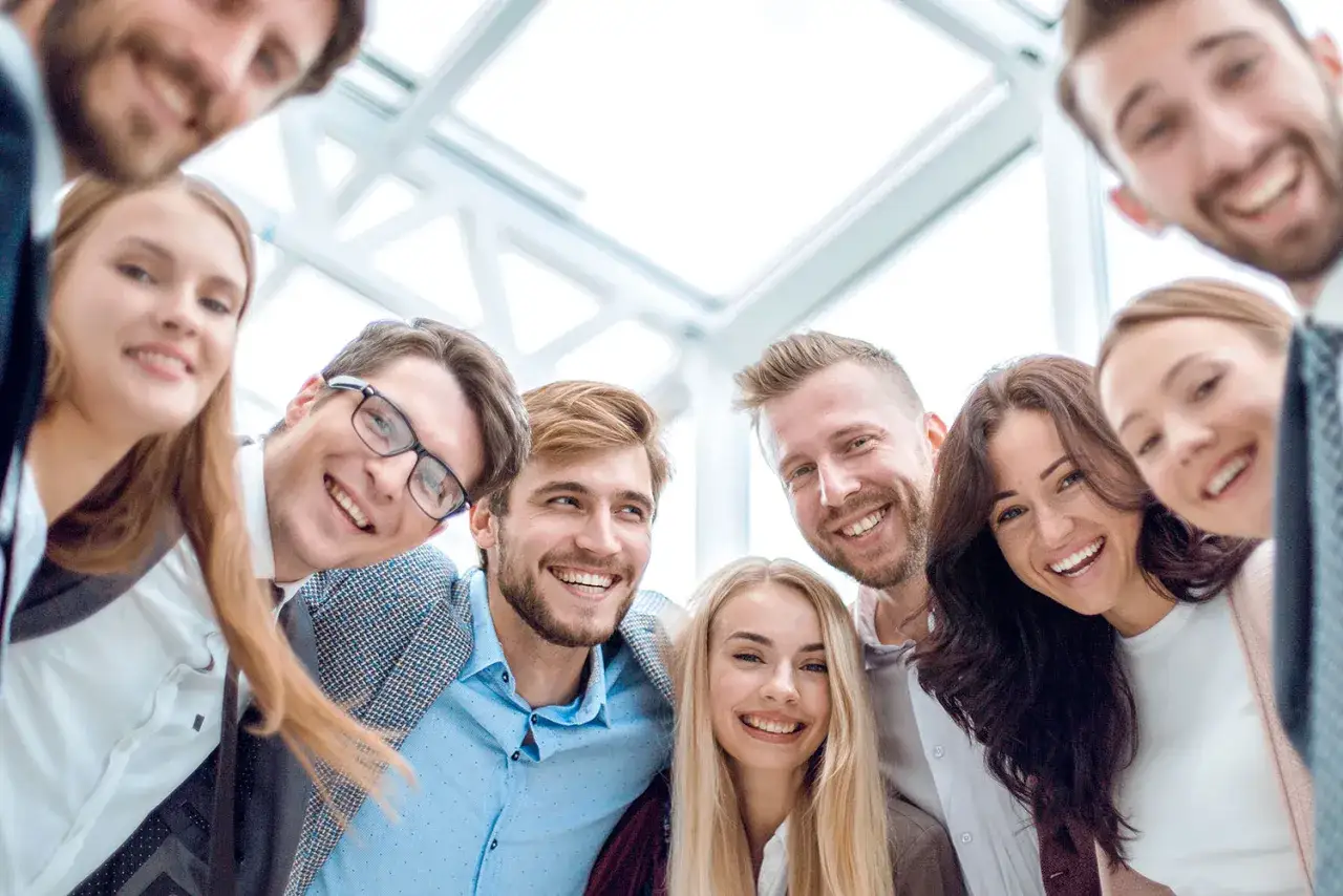Eine Gruppe lachender junger Leute, die sich für ein Foto versammeln. Sie scheinen gut zusammenzupassen, wie bei den